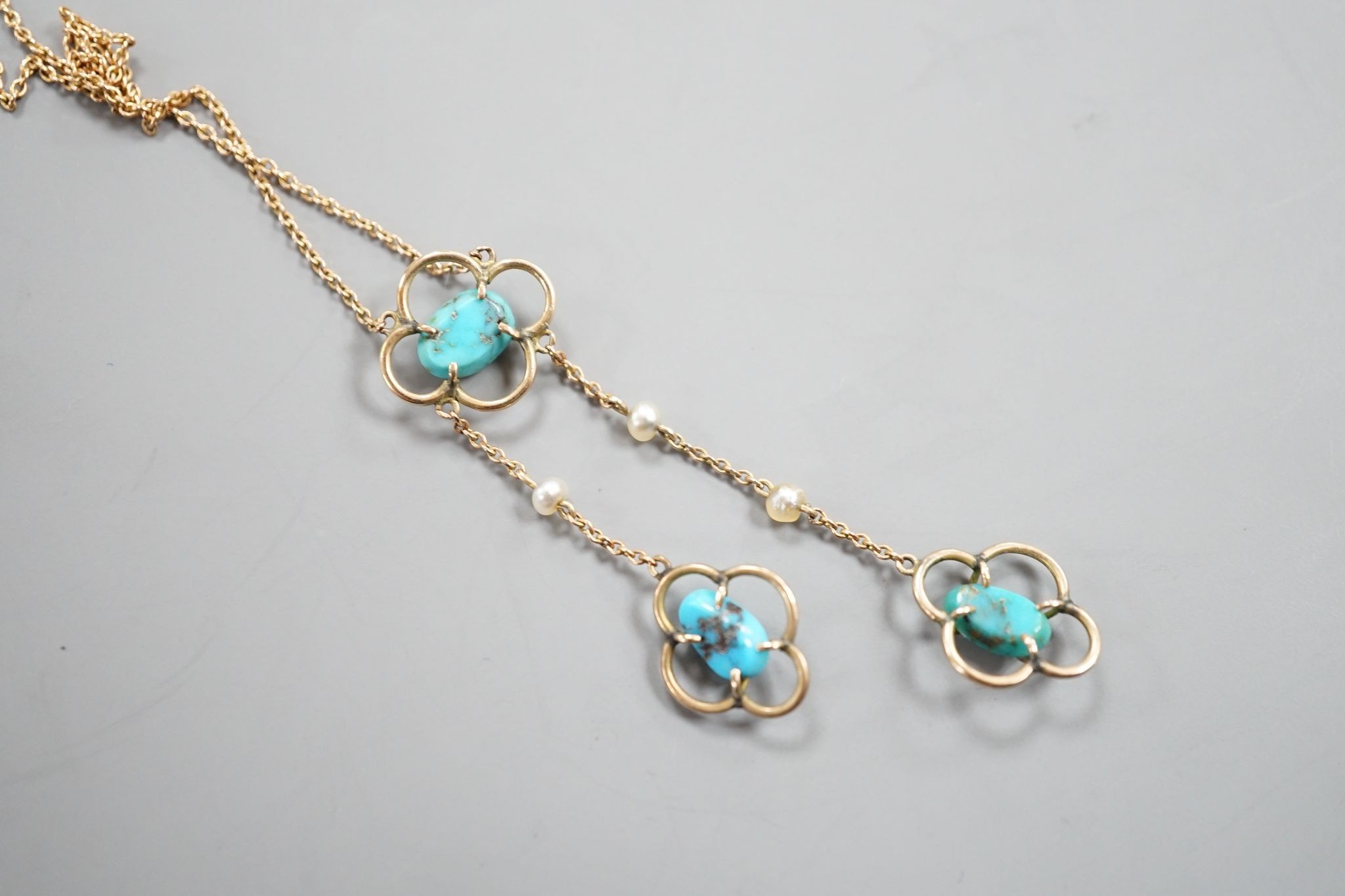 An Edwardian 9ct , three stone turquoise and three stone seed pearl set graduated double drop pendant necklace, 50cm, gross weight 3.1 grams.